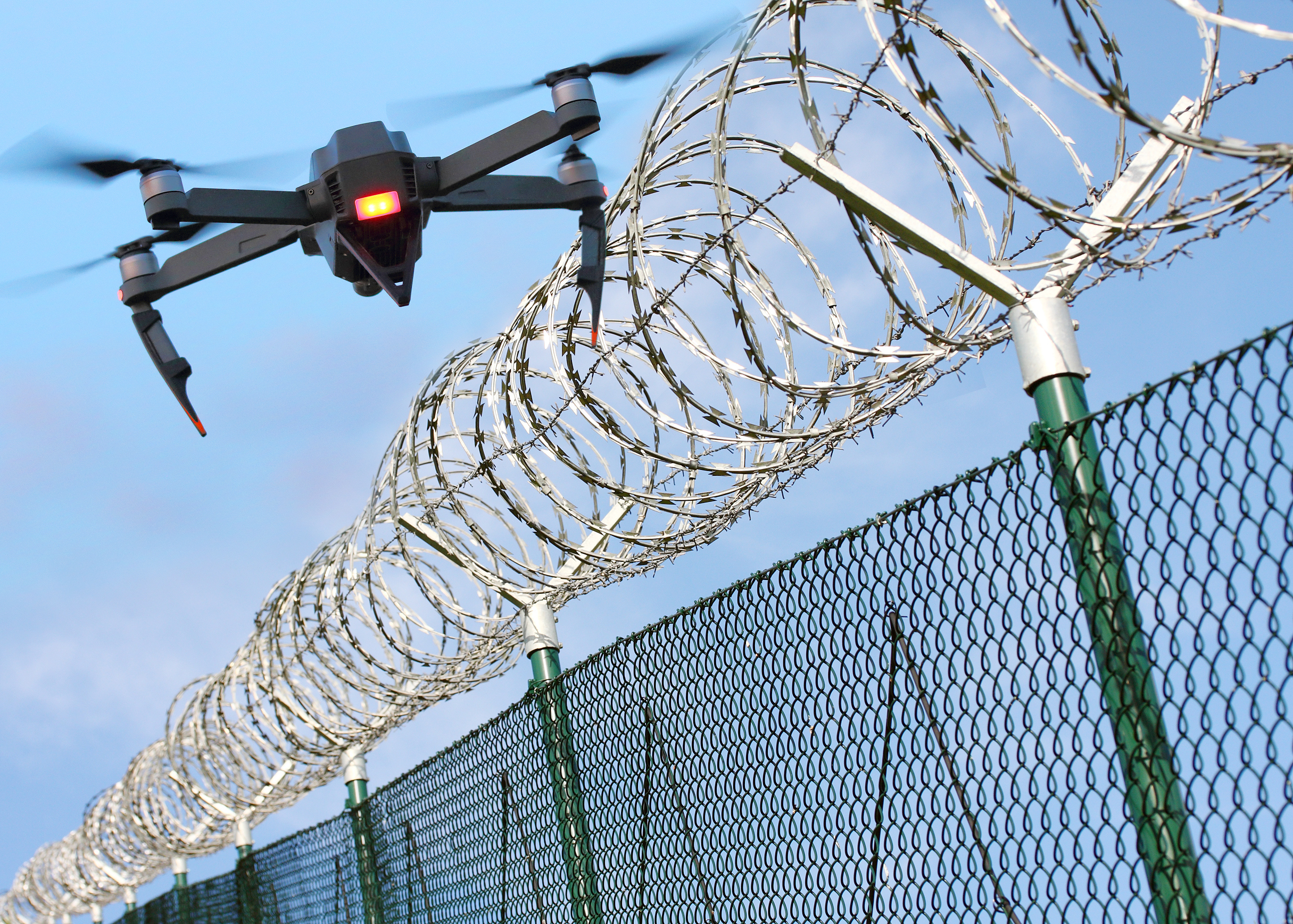 Drone monitoring barbed wire fence on state border or restricted area. Drone monitoring barbed wire fence on state border or restricted area. Modern technology for security. Digital artwork with fictive vehicle.